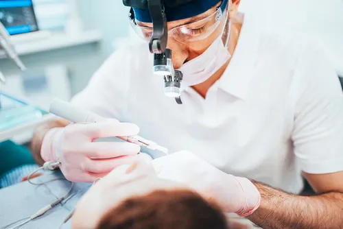 endodontist wearing surgical loupes performing a root canal procedure