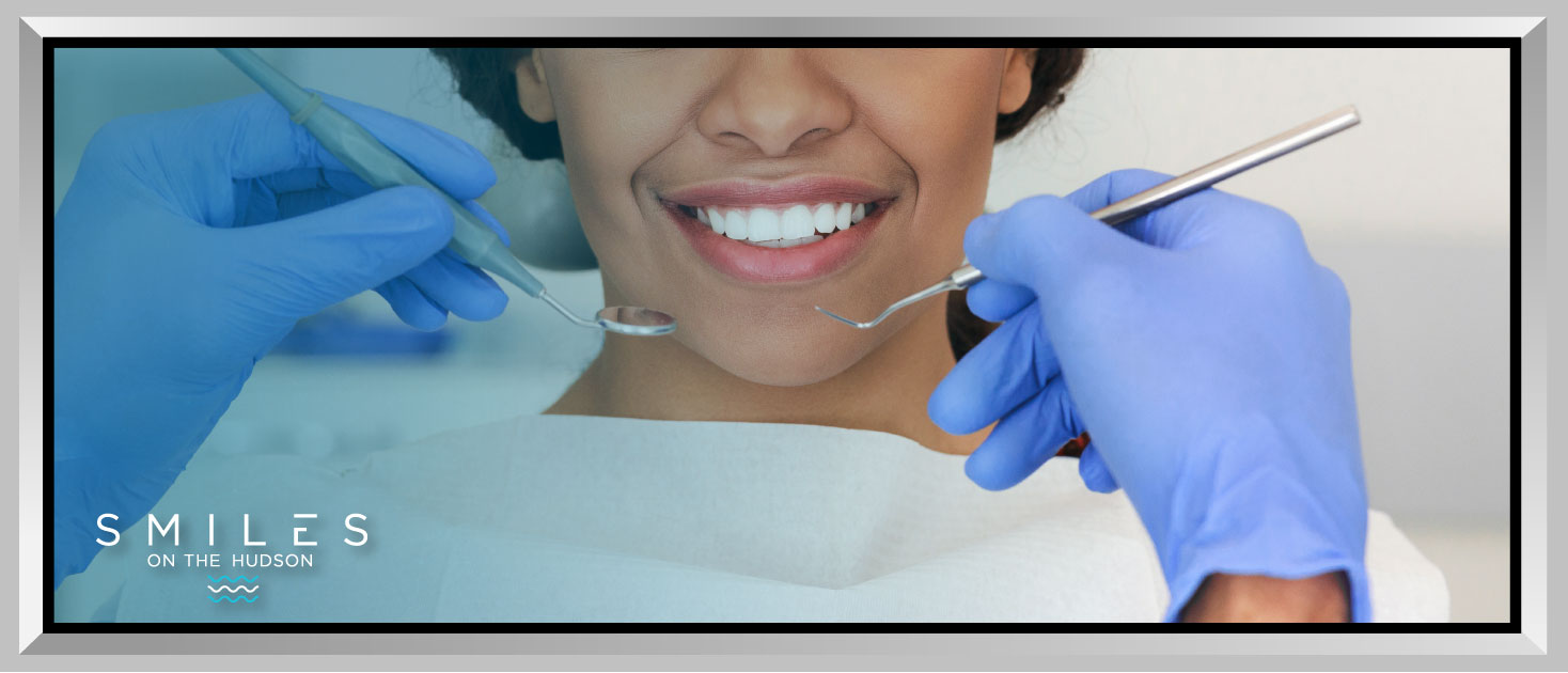 Dental professional examining a smiling patient in a dental office, showcasing preventive care and oral hygiene.